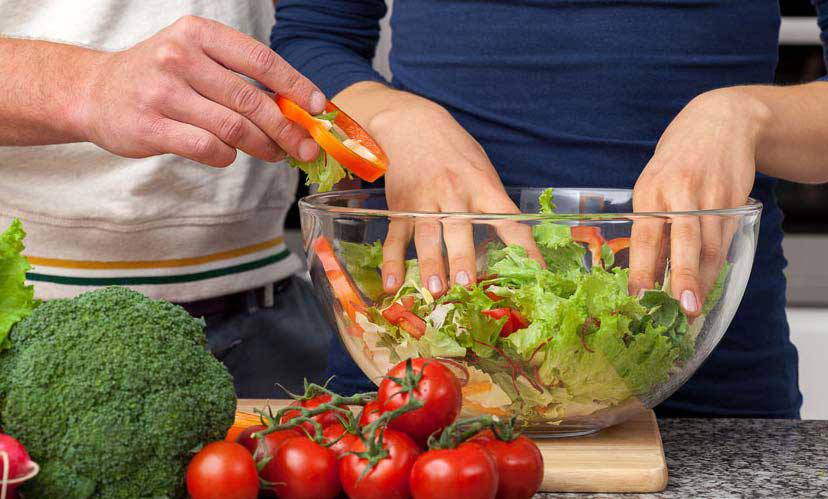 Laitue fraîche dans un bol avec tomates raisins et brocolis en accompagnement