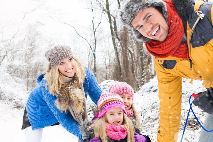 Une famille contente joue dans la neige