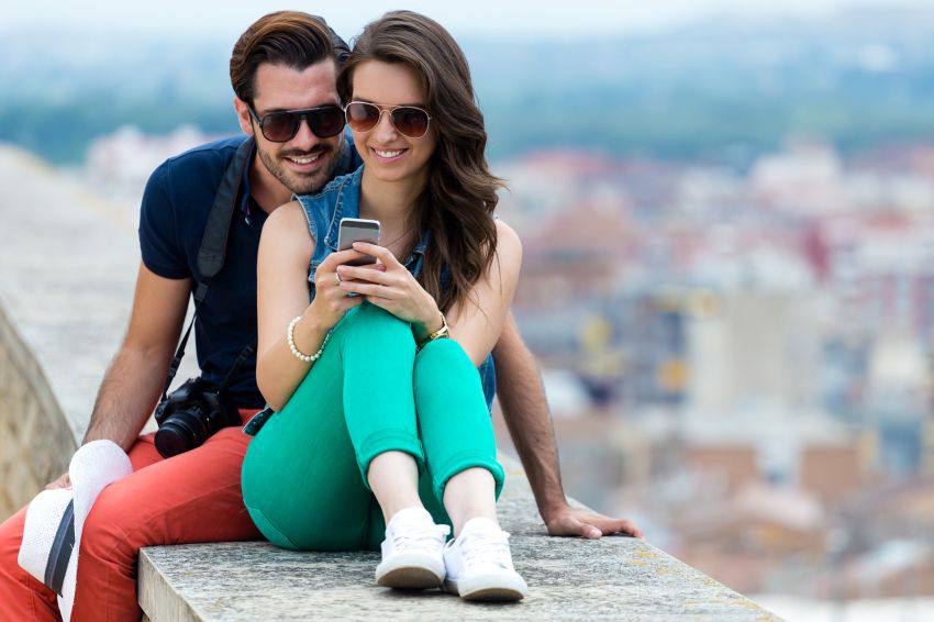 Un couple en voyage sur le téléphone