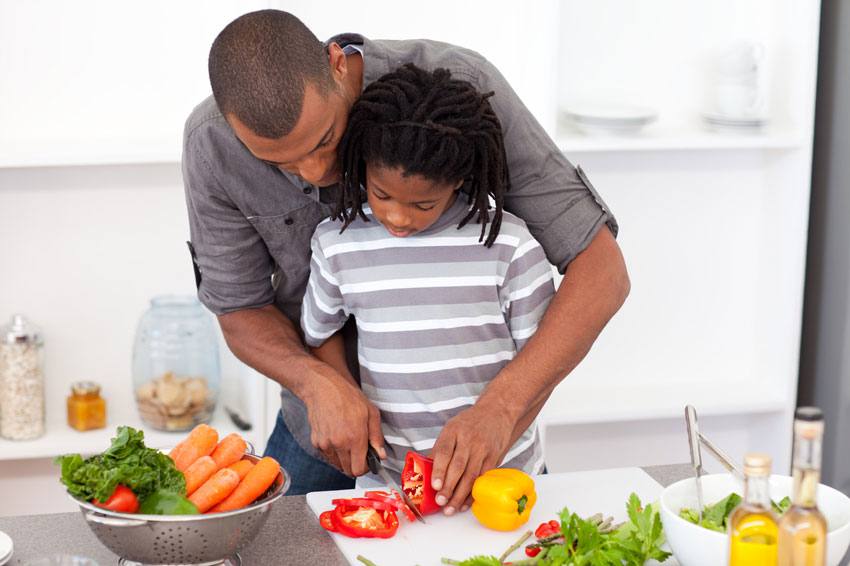 Un homme cuisine avec son enfant