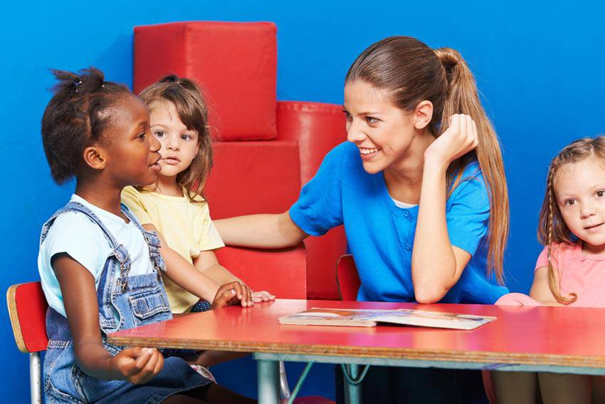 Éducatrice qui parle avec plusieurs enfants