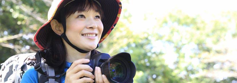 Une madame contente en voyage prend des photos