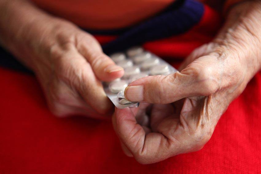 Personne âgée prend des pillules