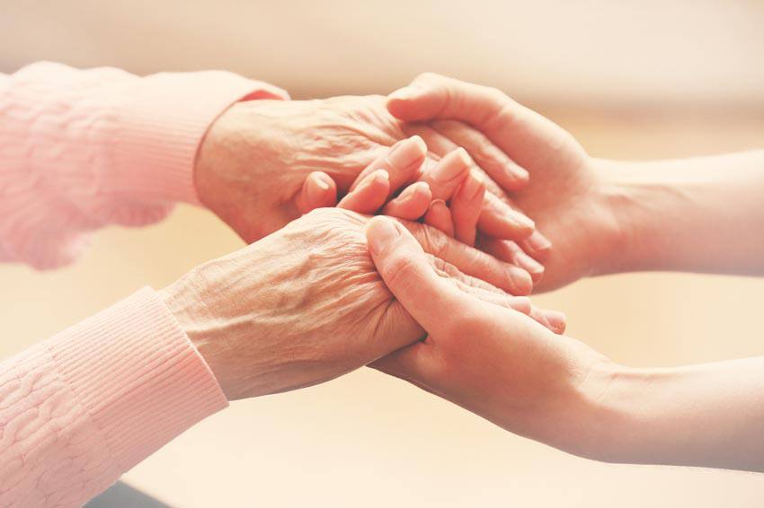 Les mains d'une personne âgée dans celles d'une jeune personne