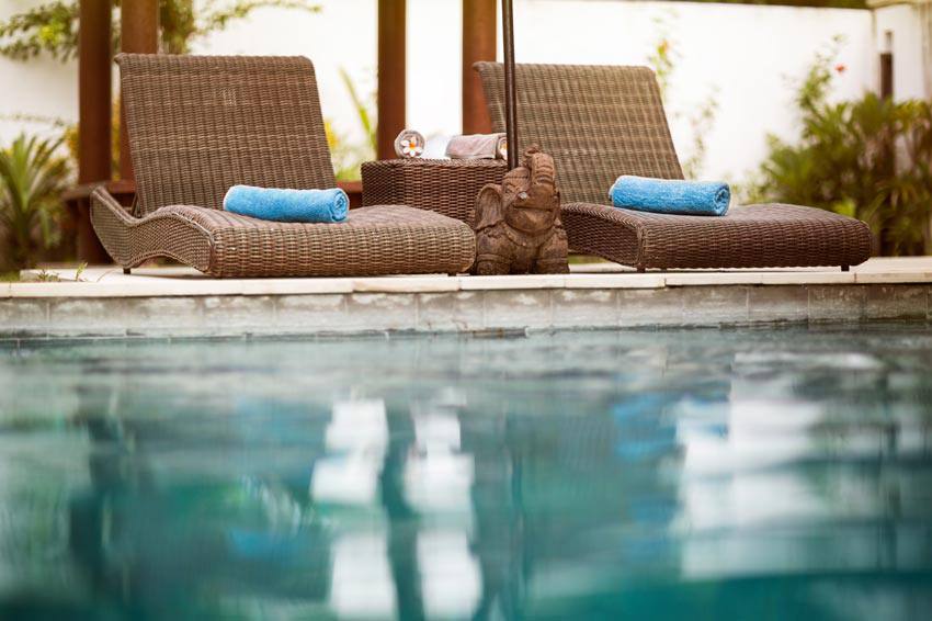 Des chaises confortables sur le bord d'une piscine