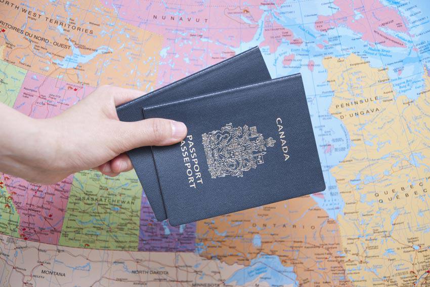 Deux passeports canadiens devant une carte du Canada