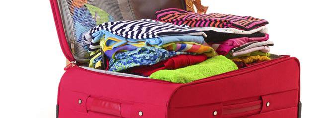 Une valise rouge remplie d'habits